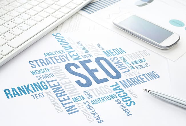 Seo business, search engine optimization, concept cloud chart. Print document, keyboard, pen and smartphone. Blue toned.